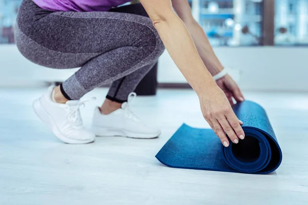 Sportliche reife Frau faltet Mattenbrett aus — Stockfoto