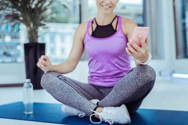 Aktive reife Frau erhält Nachricht im Fitnessstudio — Stockfoto