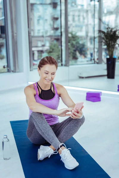 Agradable mujer madura tomando selfie durante el entrenamiento — Foto de Stock