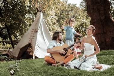 Yaratıcı aile çadır yakınındaki müzik aletleri çalmaya