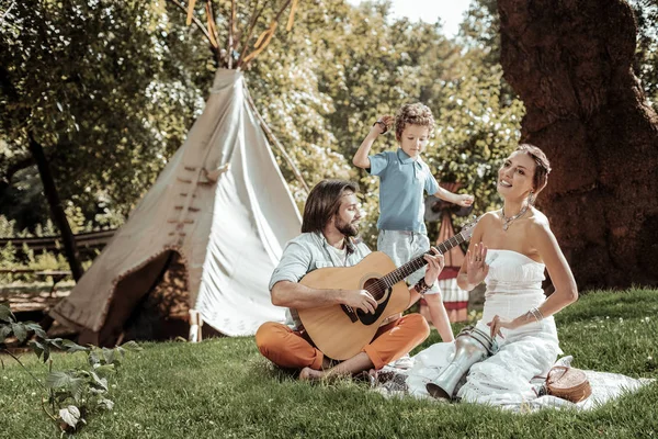 Família criativa tocando instrumentos musicais perto da tenda — Fotografia de Stock