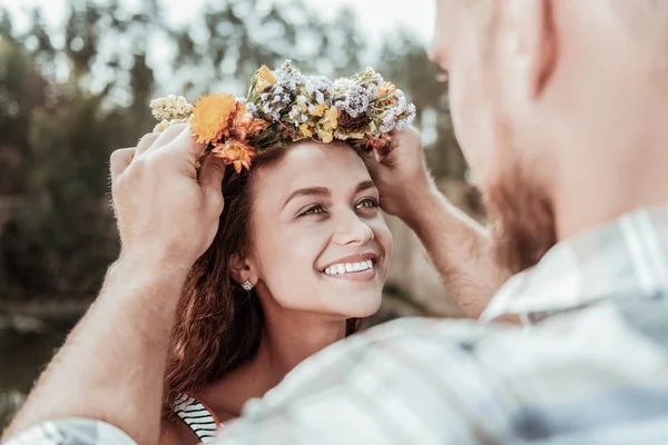 Schöne grünäugige Frau, die sich extrem glücklich fühlt, ein schönes florales Chaplet zu erhalten — Stockfoto