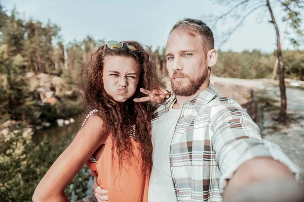 Söt älskande par att göra mycket roliga ansikten samtidigt selfie tillsammans — Stockfoto