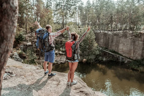 Duygu genç ve ücretsiz rock kenarında ayakta backpackers birkaç — Stok fotoğraf