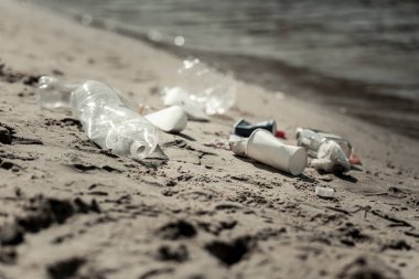 Kahve bardakları ve boş şişeler kum üzerinde Nehri yakınında döşeme yakın çekim