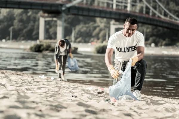 Hermano mayor uniéndose a su hermano mientras trabajaba como voluntario en la playa — Foto de Stock