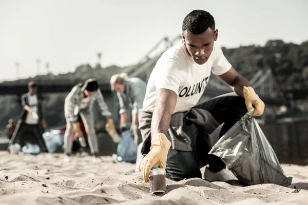 Hermoso estudiante disfrutando del proceso de voluntariado mientras limpia la basura — Foto de Stock