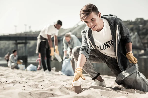 Jongen dragen sport jas lopen met vuilniszak en het schoonmaken van de Prullenbak — Stockfoto