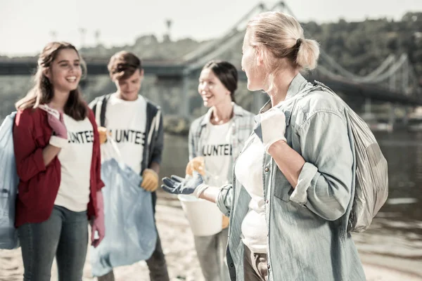 Bedrijf van leraar en leerlingen lopen met vuilniszakken opschonen van de Prullenbak — Stockfoto