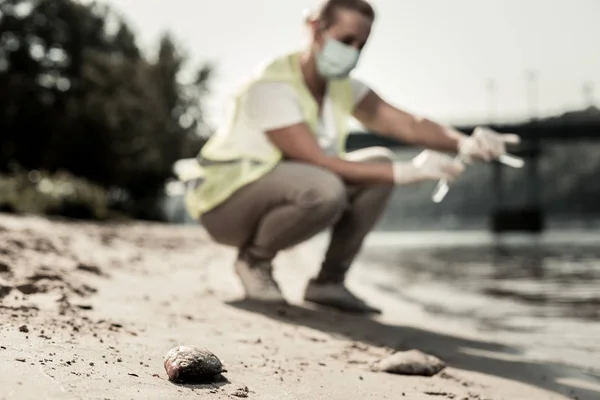 Sand and little stones neat the river while inspector checking purity of water — Stock Photo, Image