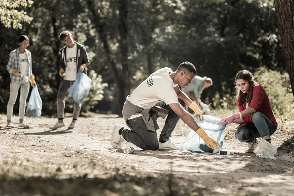 Компания добросовестных волонтеров, убирающих мусор, оставленный в лесу — стоковое фото