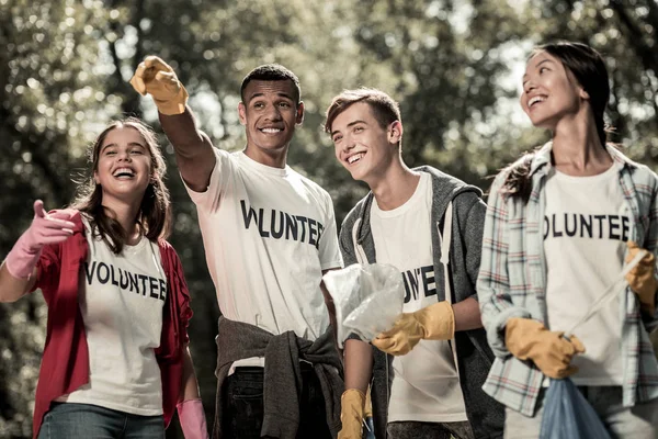 Estudiantes divertidos vistiendo camisa blanca con bosque de limpieza de letreros voluntarios —  Fotos de Stock