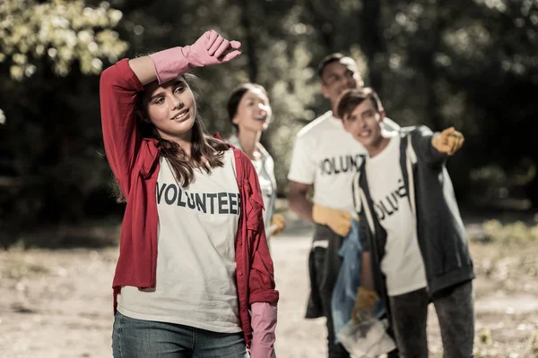 Chica morena usando guantes rosados sintiéndose cansada después de ser voluntaria todo el día — Foto de Stock