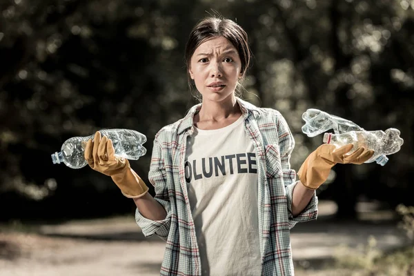 Frau mit Handschuhen fühlt sich gestresst, nachdem sie zu viel Müll im Wald gefunden hat — Stockfoto
