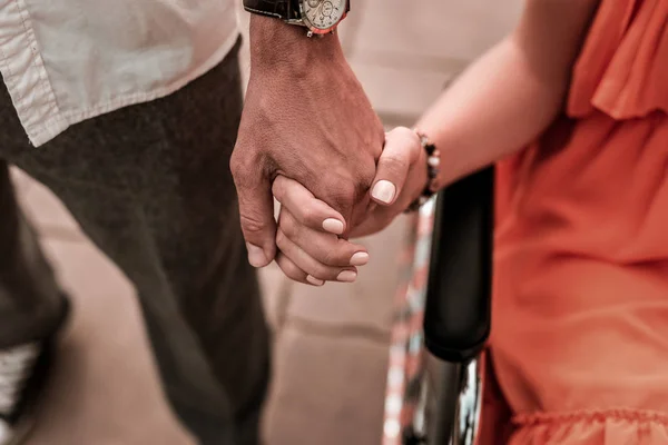 Zelfverzekerde man met hand van zijn geliefde handicap vriendin — Stockfoto