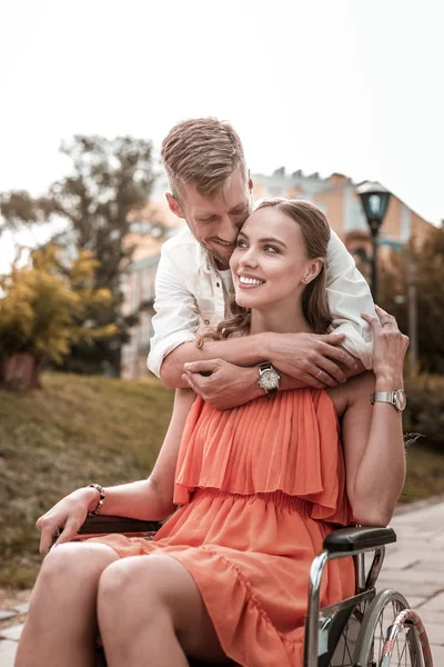 Schattig handicap meisje glimlachend en liefdevolle vriend haar knuffelen — Stockfoto