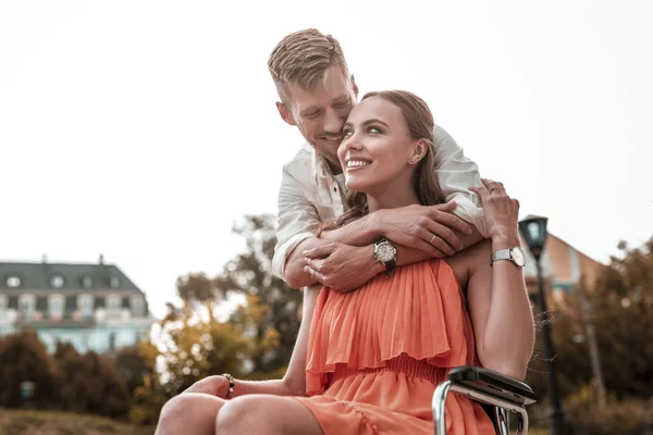 Behinderte Mädchen fühlen sich glücklich, während schöner Mann sie umarmt — Stockfoto