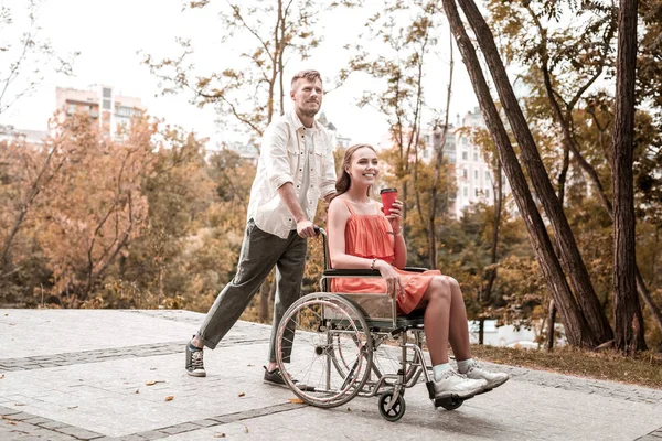 Romantiska man promenader med funktionshindrade flickvän i parken och leende — Stockfoto