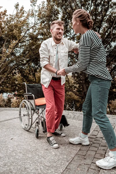 Trabajadora social confiable ayudando a su paciente discapacitado a ponerse de pie — Foto de Stock