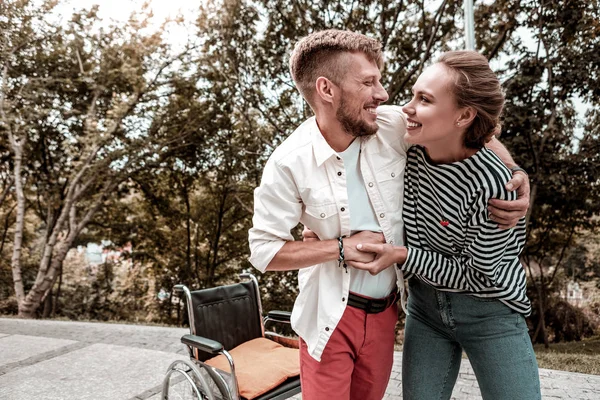 Behinderter lächelt im Stehen aus seinem Rollstuhl — Stockfoto