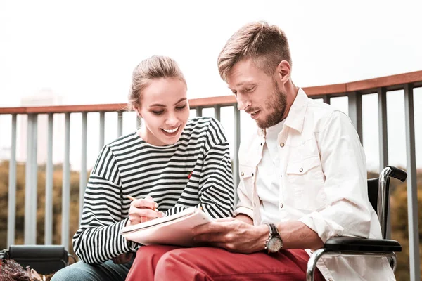 Deux personnes souriant tout en prenant des notes ensemble — Photo