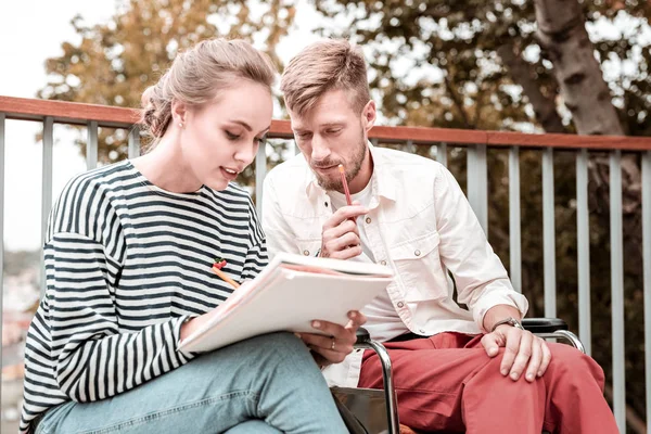 Jóvenes sentados en el parque y tomando notas para el trabajo — Foto de Stock