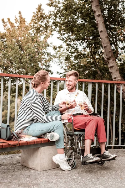 Femme détendue assise avec un homme handicapé et mangeant des aliments sains — Photo