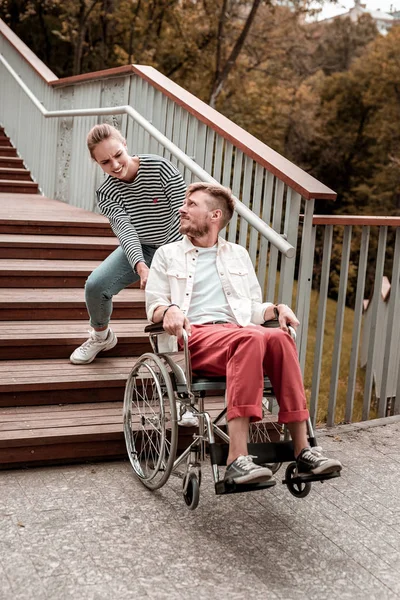 Triest ongeldige man kijken naar de kleine vrouw met zijn rolstoel — Stockfoto