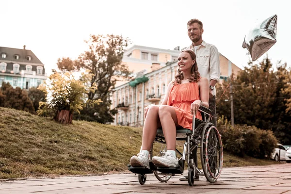 Chica discapacitada sonriendo mientras tiene un día agradable con su novio — Foto de Stock