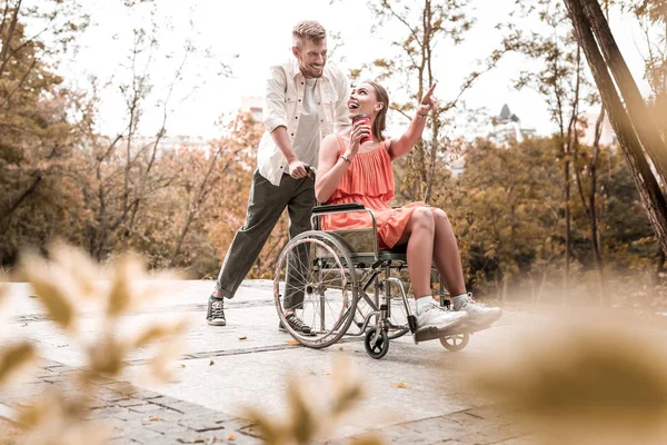 Upphetsad ogiltig pekar på avståndet och ser glad — Stockfoto