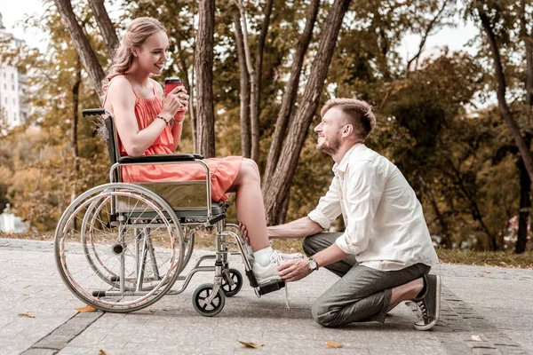 Fürsorglicher Mann sitzt auf seinen Hinterbeinen und berührt das Bein einer geliebten Frau — Stockfoto