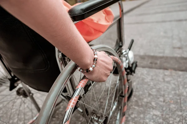 Närbild av ung flicka sitter i rullstolen utomhus — Stockfoto