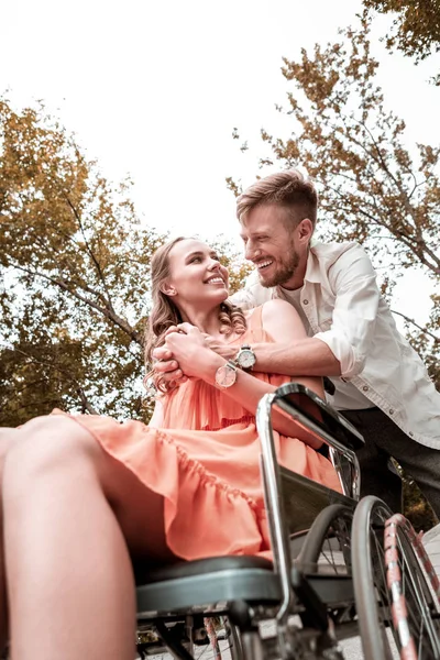 Positiver Mann lacht, während er geliebte behinderte Frau umarmt — Stockfoto