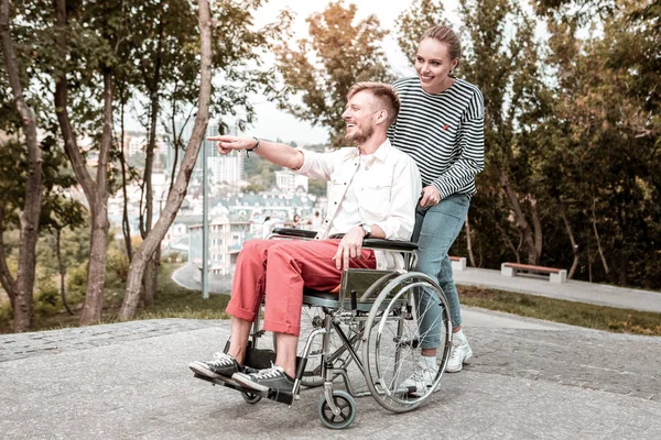 Hombre discapacitado sonriendo y señalando a la distancia durante la caminata — Foto de Stock