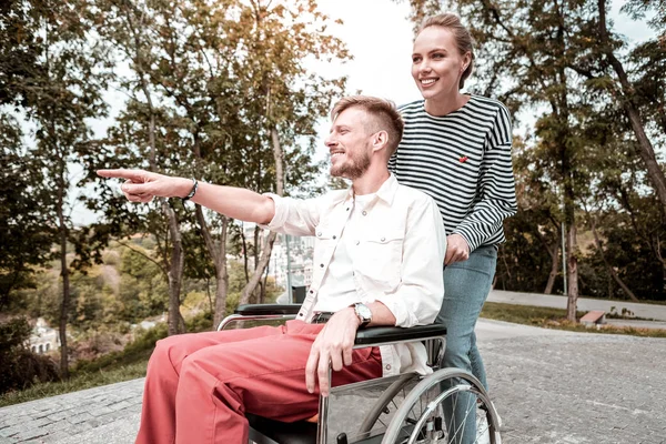 Hombre discapacitado sentirse feliz mientras muestra el parque a su novia bonita — Foto de Stock