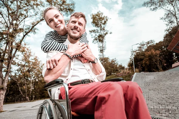 Rustige man in de rolstoel zitten en genieten van zonnige dag met vriendin — Stockfoto