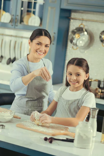 Lycklig mor och barn matlagning något på köket — Stockfoto