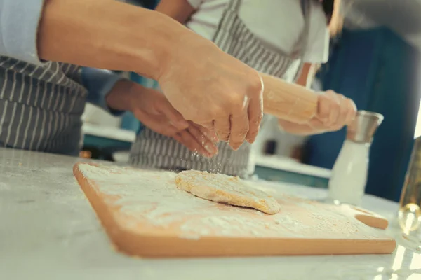 View of womans hands making dough with daughter