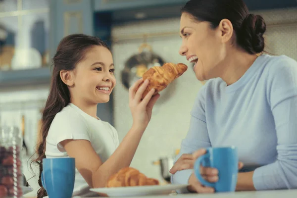 Doce menina bonita alimentando sua mãe agradável — Fotografia de Stock