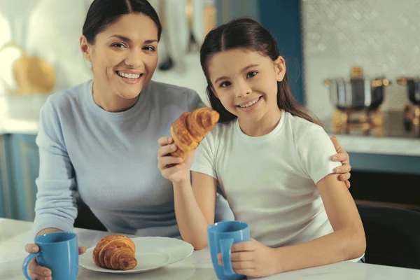 Família alegre tomando café da manhã na cozinha — Fotografia de Stock