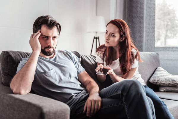 Unhappy young woman holding a smartphone