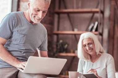 Bir dizüstü bilgisayar ile neşeli yaşlı adam portresi