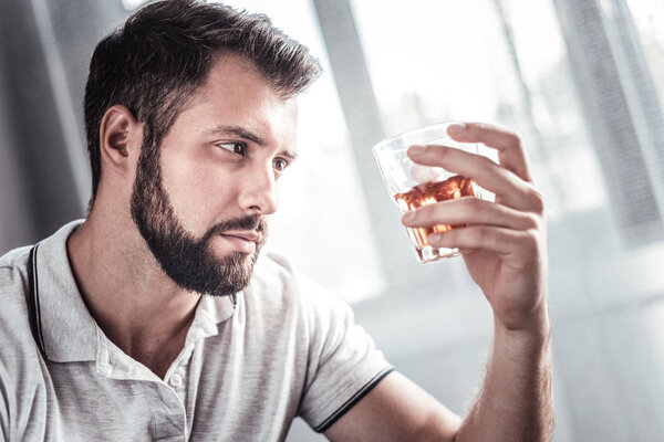 Depressed unhappy man looking at the glass