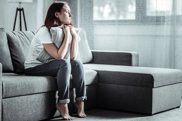 Thoughtful girl embracing soft pillows — Stock Photo, Image