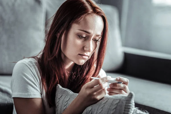 Persona femminile attenta guardando il termometro — Foto Stock