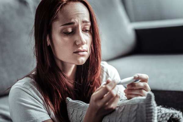 Worried girl checking her temperature