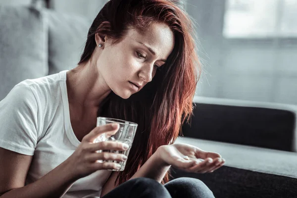 錠剤を見て動揺して若い女性 — ストック写真