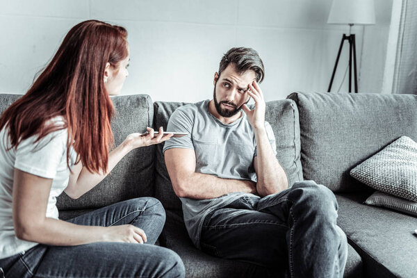 Negative delighted bearded man listening to his partner