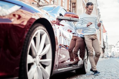 Olumlu memnun adam arabasına yaslanmış