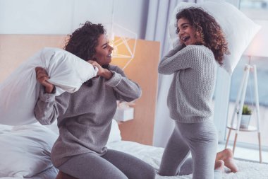 Mutlu kardeşler yastık savaşı yaparken neşeli hissediyorum